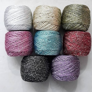 Può includere: Otto bobine di filo scintillante in vari colori, tra cui argento, oro, verde, rosa, blu, rosso, nero e viola.
