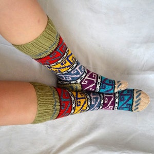 May include: A pair of colorful knee-high socks with a geometric pattern in shades of green, yellow, red, blue, and purple. The socks are made of a soft, knitted fabric.