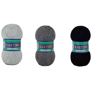 May include: Three skeins of yarn in gray, dark gray, and black. Each skein has a label that reads "KARTOPU SUPER PERLE" in white text on a green and blue background. The yarn is tightly wound into a ball shape.