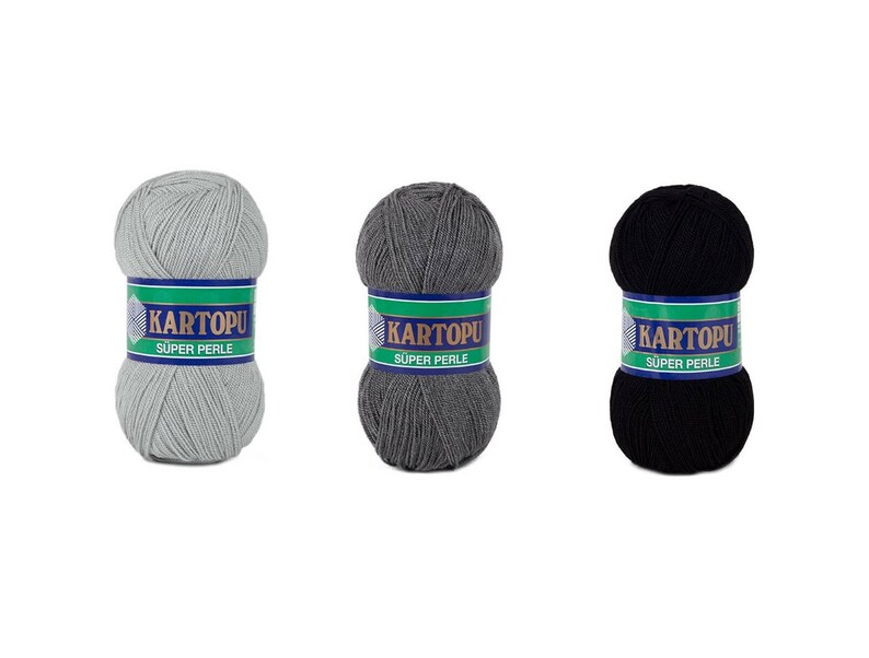 May include: Three skeins of yarn in gray, dark gray, and black. Each skein has a label that reads "KARTOPU SUPER PERLE" in white text on a green and blue background. The yarn is tightly wound into a ball shape.