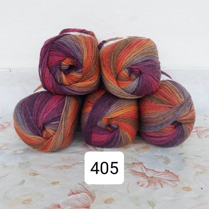 May include: Five balls of yarn in a multi-colored pattern of orange, brown, and purple. The yarn is arranged in a pyramid shape. The number 405 is printed on a white label below the yarn.