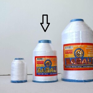 May include: Three spools of white thread with blue trim. The spools are labeled "YABALI" and "KAR BEYAZ" in Turkish. The largest spool is labeled "NO:50".