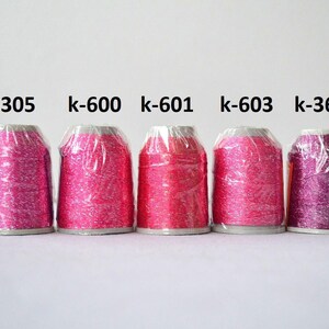 May include: Five spools of metallic embroidery thread in various shades of pink and purple. The spools are labeled with the following numbers: k-305, k-600, k-601, k-603, and k-3685.