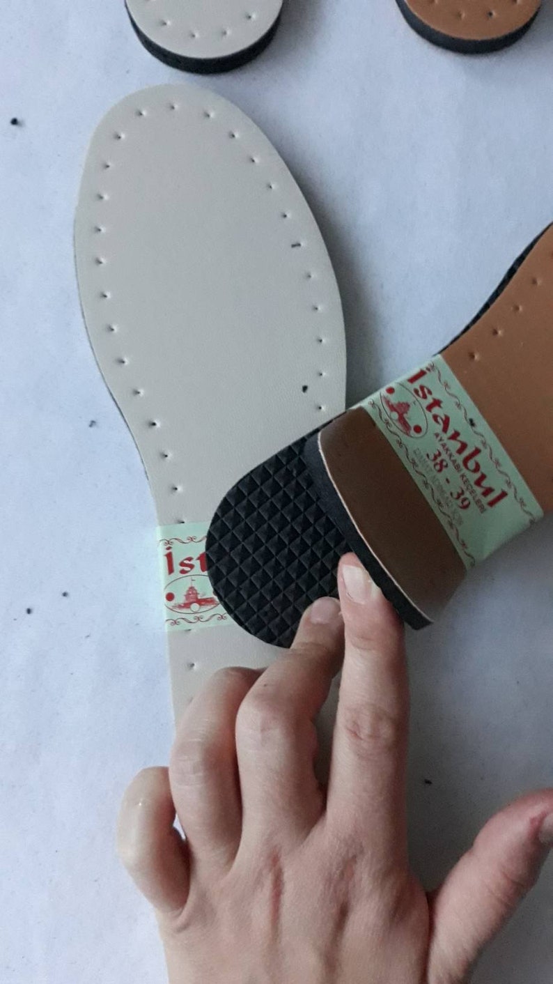 May include: A white leather shoe sole with a black rubber heel and a label that says "Istanbul Ayakkabı Kutusu 38-39".