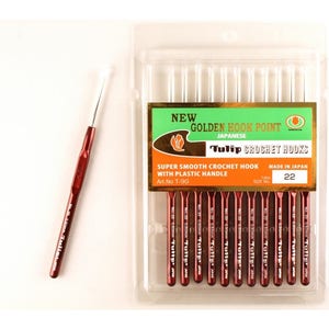 May include: A package of 10 Tulip brand crochet hooks, size 22, with golden hook points and plastic handles. The package is labeled "New Golden Hook Point Japanese Tulip Crochet Hooks Super Smooth Crochet Hook with Plastic Handle Art. No T-9G Made in Japan Size No 22".