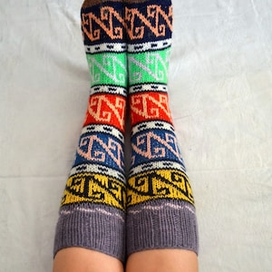 May include: A pair of colorful knitted socks with a geometric pattern in shades of brown, orange, yellow, green, blue, and pink. The socks are made of a soft, warm material and are perfect for keeping your feet cozy in the winter.