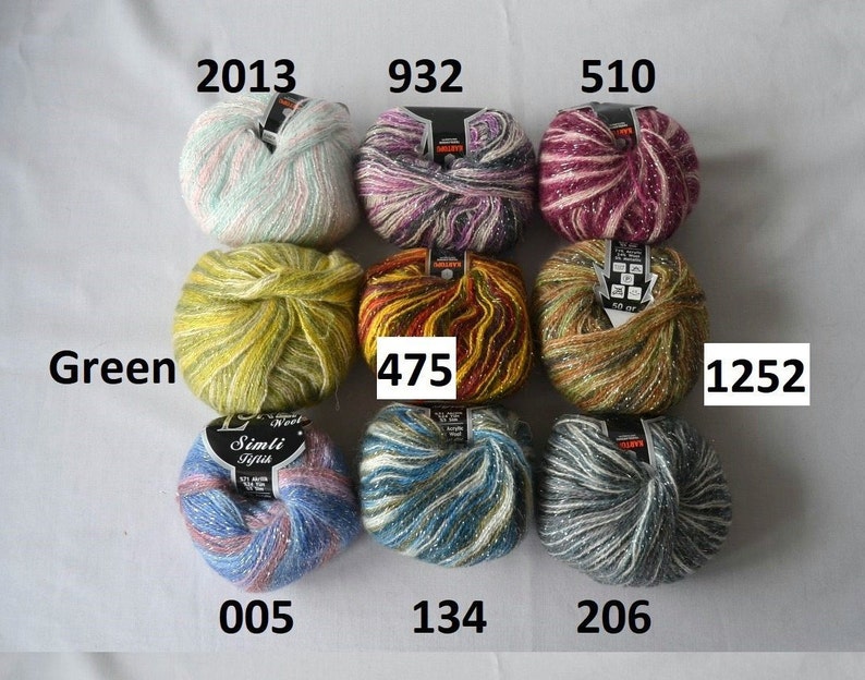 Puede incluir: Nueve ovillos de lana en varios colores y patrones, incluyendo verde, amarillo, rojo, morado, rosa, azul y gris. Cada ovillo tiene una etiqueta con un n&uacute;mero, como 2013, 932, 510, 475, 1252, 005, 134 y 206.