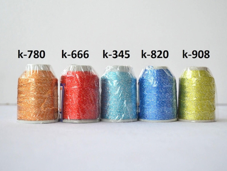 May include: Five spools of metallic thread in different colors: gold, red, turquoise, blue, and green. The spools are labeled with the following codes: k-780, k-666, k-345, k-820, and k-908.