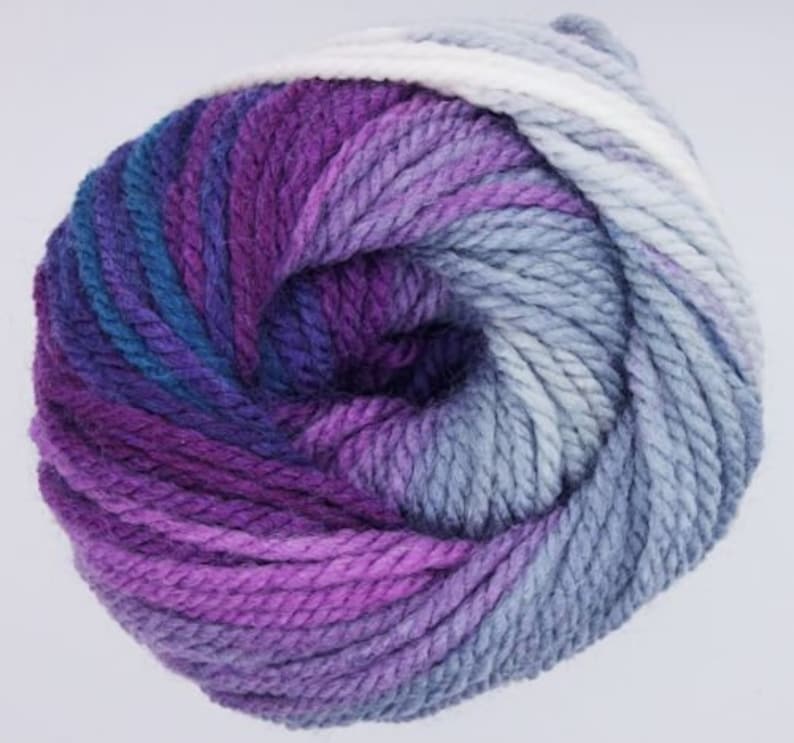 May include: A skein of yarn in a purple, blue, and white ombre colorway. The yarn is soft and fluffy, and it would be perfect for knitting or crocheting a cozy blanket or scarf.