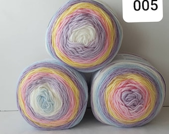 May include: Three balls of yarn in a rainbow colour pattern. The yarn is a light blue, white, pink, yellow, and purple colour. The yarn is in a circular shape and is ready to be used for knitting or crocheting.