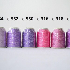 May include: Six spools of metallic embroidery thread in various shades of purple and pink. The spools are labeled with the following color codes: c-554, c-552, c-550, c-316, c-318, and c-918.