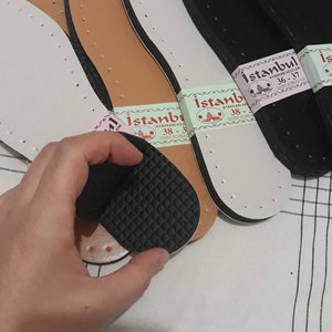 May include: Four pairs of shoe insoles, two brown, one white, and one black. The insoles are labeled "Istanbul Ayakkabı Keczileri 36-37" and "Istanbul Ayakkabı Keczileri 38-39".
