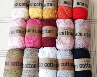 May include: A collection of 12 balls of yarn in various colors, including white, yellow, red, pink, brown, and black. The yarn balls are labeled with the text "eco cotton", "gold cotton", and "cotton".