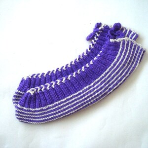 May include: Purple and white striped knitted slipper socks with a white braided trim.
