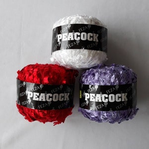 May include: Three balls of yarn in red, white, and purple. Each ball has a black label that says "FEZA" and "PEACOCK".