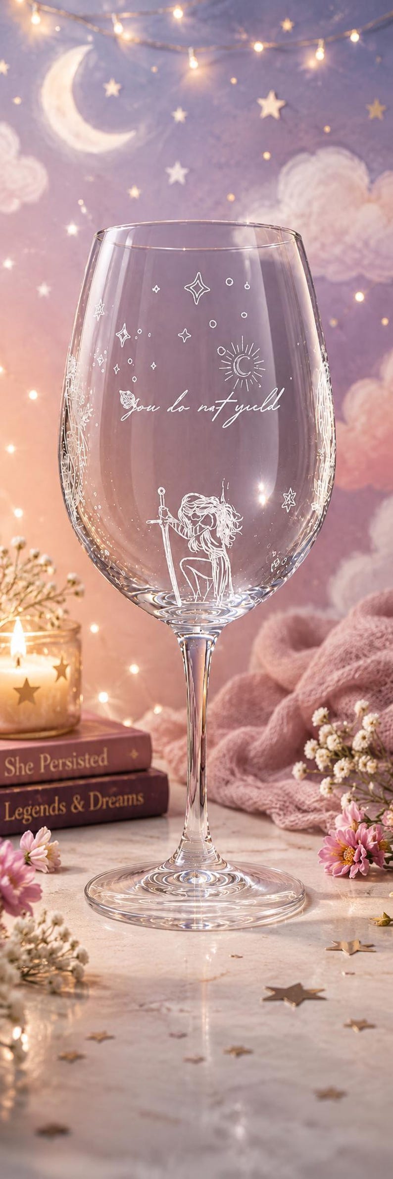 May include: A clear glass wine goblet featuring white etched designs of stars, a sun, and a figure kneeling with a sword. The text "You do not yield" is etched in a cursive script across the center of the glass bowl above the figure.