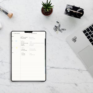 May include: A digital tablet displaying a weather vocabulary lesson plan with lined paper, a small potted succulent, a black alarm clock, paper clips, and a laptop with a sticker. The tablet screen shows text including Weather Vocabulary.