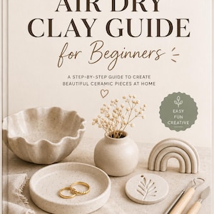 Puede incluir: Un libro de tapa dura titulado Air Dry Clay Guide for Beginners con una cubierta color crema y texto marrón oscuro. La portada muestra un cuenco de arcilla moteado, un jarrón pequeño con flores secas, una escultura de arcoíris y herramientas.