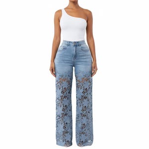 May include: A white one-shoulder bodysuit paired with light blue denim jeans. The jeans feature a high-waisted design with a classic button and zipper closure, and the lower legs are crafted from intricate, semi-sheer blue floral lace.