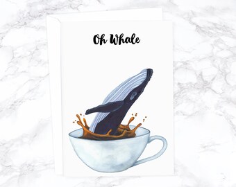 May include: A greeting card with a watercolor illustration of a whale jumping into a cup of coffee. The text "Oh Whale" is written in black cursive at the top of the card.