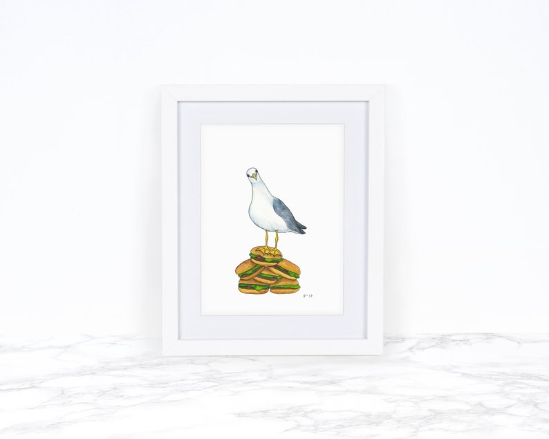 Puede incluir: Una pintura de acuarela de una gaviota de pie sobre una pila de cinco hamburguesas. La gaviota mira hacia la izquierda y tiene una cabeza blanca y un cuerpo gris. Las hamburguesas son marrones y tienen lechuga verde y queso amarillo.