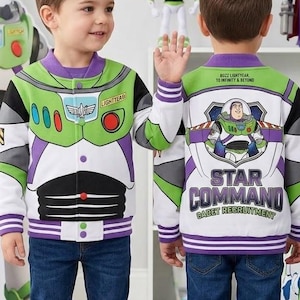 May include: A white, green, and purple varsity-style jacket featuring Buzz Lightyear graphics. The front displays a space ranger chest plate design, while the back features a Buzz Lightyear illustration with the text Star Command Cadet Recruitment.