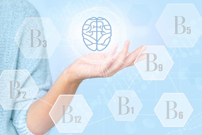 May include: A light blue graphic illustration featuring a central blue brain icon surrounded by a circular pattern. Hexagonal shapes containing the text B1, B2, B3, B5, B6, B9, and B12 are arranged around the brain, set against a soft blue background.