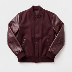 Op de afbeelding: Een bordeauxrood varsity-jack met een body van wolmix en bijpassende leren mouwen. Het jack is voorzien van een geribbelde kraag, boorden en zoom, een sluiting met drukknopen aan de voorzijde en twee steekzakken met een leren afwerking.