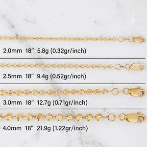May include: Four gold-tone bead chains of varying thicknesses, labeled 2.0mm, 2.5mm, 3.0mm, and 4.0mm. Each chain is 18 inches long with weights of 5.8g, 9.4g, 12.7g, and 21.9g respectively, featuring lobster claw clasps at the ends.