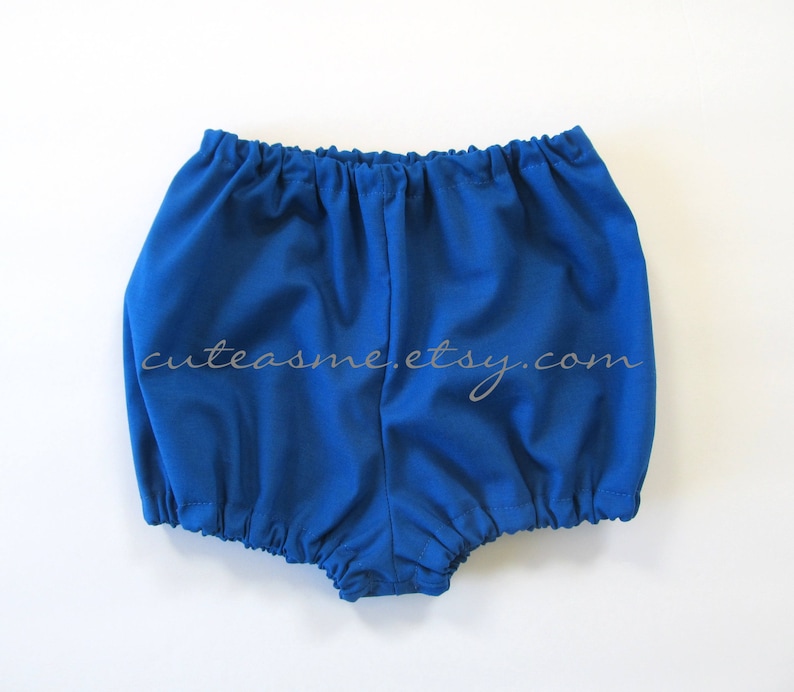 May include: Royal blue baby bloomers with a gathered elastic waistband. The bloomers are made of a soft, comfortable fabric.