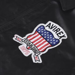 May include: A black leather jacket featuring an embroidered patch on the chest. The patch displays the text AVIREX, ESTABLISHED 1975, and N.Y. along with a graphic of the American flag shaped like a shield with red, white, and blue colors.