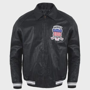 May include: A black leather jacket featuring a front zipper closure, a classic collar, and long sleeves. On the left chest, there is an embroidered patch displaying the text AVIREX, a shield with the American flag, and the text ESTABLISHED 1975.
