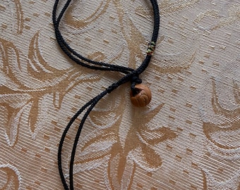 Pulseira artesanal de cordão trançado preto, pulseira minimalista ajustável com pingente que imita madeira e contas vermelhas como detalhe. Ideal para presente.
