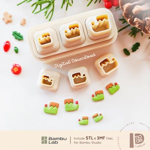 Pode incluir: Um conjunto de cortadores de biscoito de plástico de cor clara com vários designs, incluindo sapatos de elfo. A imagem mostra um recipiente retangular com três cortadores, três soltos e várias formas de argila verde e laranja. Texto: Digital Download, Bambu Lab e Include STL & 3MF Files for Bambu Studio.