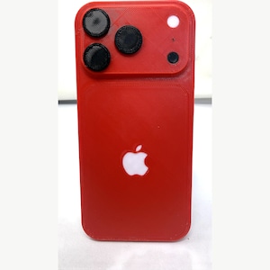 May include: A bright red smartphone case with a textured, 3D-printed finish. The back features a prominent camera module with three circular black lens covers, a small circular flash cutout, and a white Apple logo centered on the lower portion.