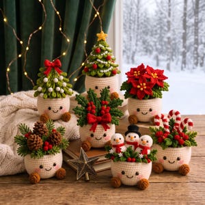 May include: A collection of six crocheted holiday decorations in cream-coloured pots with smiling faces. The set includes a Christmas tree, a poinsettia, pinecones with greenery, holly with a red bow, three small snowmen, and candy canes.