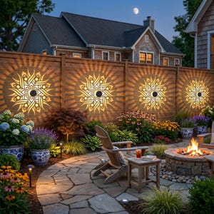 Peut inclure: Quatre appliques solaires circulaires avec des découpes complexes de style mandala montées sur une clôture en bois, projetant des motifs lumineux chauds et rayonnants. La scène comprend un patio en pierre, un brasero, une chaise en bois et des plantes.