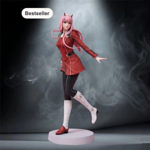 May include: A figurine of a character with long pink hair and small red horns, wearing a red military-style jacket, a short skirt, black leggings, and white boots. The figure stands on a circular base with a Bestseller label in the corner.