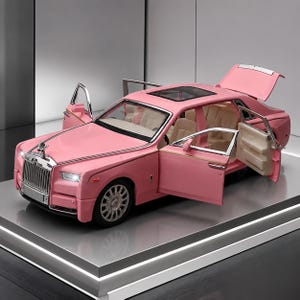 May include: A pink scale model luxury sedan featuring a silver grille, a hood ornament, and a sunroof. The vehicle has four doors and a trunk that are open, revealing a beige interior with seats. The car has silver wheels and illuminated headlights.