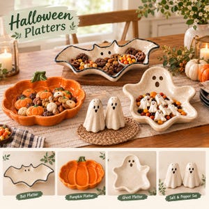 May include: A collection of Halloween-themed ceramic serveware including a bat-shaped platter, a pumpkin-shaped orange platter, a ghost-shaped platter, and a pair of ghost-shaped salt and pepper shakers, all filled with various small candies.