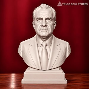 May include: A light-colored bust sculpture of Richard Nixon featuring a detailed facial expression, wearing a suit jacket, collared shirt, and necktie. The sculpture is mounted on a rectangular base and includes the text TRIGO SCULPTURES.