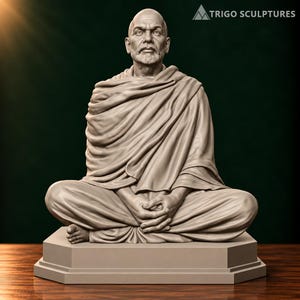Könnte beinhalten: Eine hellgraue Skulptur einer kahlköpfigen, bärtigen Person, die im Schneidersitz auf einem sechseckigen Sockel sitzt. Die Figur trägt drapierte Gewänder, die Rumpf und Beine bedecken, wobei die Hände im Schoß ruhen. Der Text TRIGO SCULPTURES ist sichtbar.