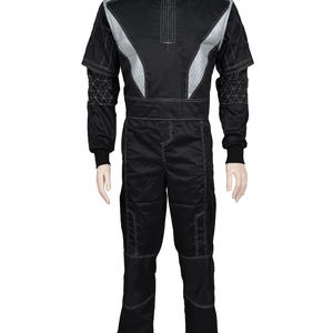May include: A black jumpsuit featuring a high collar, silver shoulder panels, and white contrast stitching. The sleeves display a geometric triangular pattern, while the pants include reinforced knee sections and a straight-leg design.