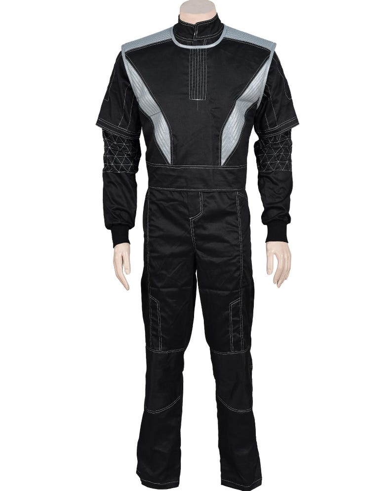 May include: A black jumpsuit featuring a high collar, silver shoulder panels, and white contrast stitching. The sleeves display a geometric triangular pattern, while the pants include reinforced knee sections and a straight-leg design.