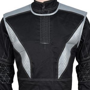 May include: A black long-sleeve jacket featuring silver-grey quilted panels on the shoulders and chest, a high collar, and white contrast stitching. The sleeves include a geometric quilted pattern on the forearms and a structured design.