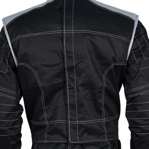 May include: A black racing jacket featuring a high collar, long sleeves, and prominent white contrast stitching throughout. The garment includes light gray panels on the shoulders and upper back, with a central vertical seam running down the back.
