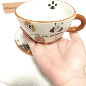 Juego de taza y platillo de cerámica con estampado de perro pintado a mano