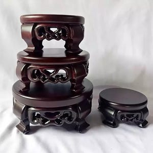 Puede incluir: Un conjunto de cuatro soportes de exhibición de madera marrón oscuro con tapas circulares y patas talladas caladas. Tres de los soportes están apilados verticalmente en orden descendente de tamaño, mientras que el cuarto está a la derecha.