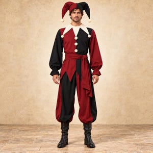 May include: A jester costume featuring a black and maroon colour-blocked long-sleeve top with a white collar, a matching waist sash, and loose-fitting trousers. The outfit includes a three-pointed jester hat with white pom-poms.
