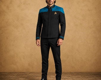 May include: A black uniform jacket with a teal yoke, a high mandarin collar, and a gold-colored delta insignia on the left chest. The jacket features a full-length front zipper, long sleeves with teal cuffs, and is paired with matching black trousers.